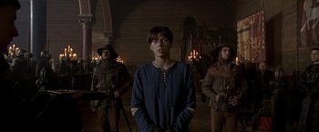 Movie still from “The Messenger: The Story of Joan of Arc” (1999), directed by Luc Besson – A group of men standing next to each other in a room; Medium shot, Low angle