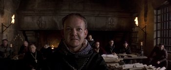 Movie still from “The Messenger: The Story of Joan of Arc” (1999), directed by Luc Besson – A group of people sitting around a table; Close Up shot, Low angle