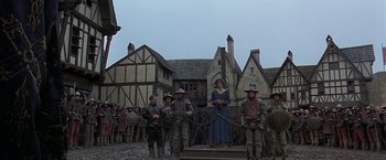 Movie still from “The Messenger: The Story of Joan of Arc” (1999), directed by Luc Besson – A group of people standing in front of a building; Wide shot, Low angle