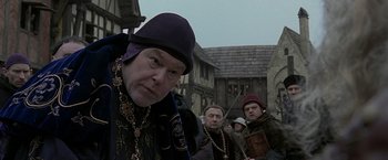 Movie still from “The Messenger: The Story of Joan of Arc” (1999), directed by Luc Besson – A group of men standing next to each other on a street; Close Up shot, Over the shoulder angle