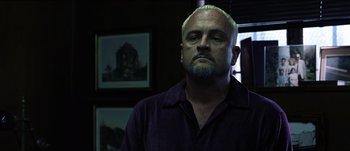 Movie still from “The Mexican” (2001), directed by Gore Verbinski – A man with a blue beard and a purple shirt; Close Up shot, Low angle