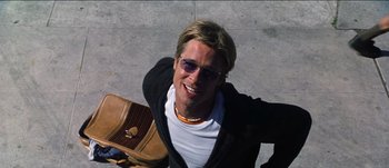 Movie still from “The Mexican” (2001), directed by Gore Verbinski – A man with sunglasses is holding a brown bag; Medium shot, Overhead angle