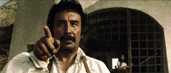 Movie still from “The Mexican” (2001), directed by Gore Verbinski – A man with a mustache is smoking a cigarette; Close Up shot, Low angle