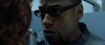 Movie still from “The Mexican” (2001), directed by Gore Verbinski – A person wearing glasses; Close Up shot, Over the shoulder angle