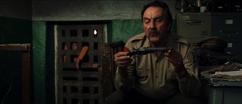 Movie still from “The Mexican” (2001), directed by Gore Verbinski – A man holding a pair of pliers in his hands; Medium shot, High angle