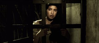 Movie still from “The Mexican” (2001), directed by Gore Verbinski – A young woman is looking through the bars of a jail cell; Close Up shot, Low angle