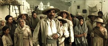 Movie still from “The Mexican” (2001), directed by Gore Verbinski – A group of men in hats are standing in a crowd; Medium shot, Low angle