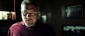 Movie still from “The Mexican” (2001), directed by Gore Verbinski – An older man with a beard and mustache looking at the camera; Close Up shot, Low angle