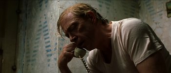 Movie still from “The Mexican” (2001), directed by Gore Verbinski – A man talking on a phone while wearing a white t - shirt; Close Up shot, Low angle