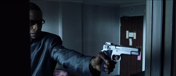 Movie still from “The Mexican” (2001), directed by Gore Verbinski – A man holding a gun in a room; Close Up shot, Low angle
