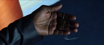 Movie still from “The Mexican” (2001), directed by Gore Verbinski – A person holding a key in their hand; Extreme Close Up shot, High angle