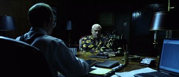 Movie still from “The Mexican” (2001), directed by Gore Verbinski – A man sitting at a table in front of another man; Medium shot, Over the shoulder angle