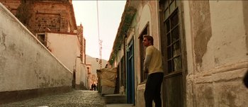 Movie still from “The Mexican” (2001), directed by Gore Verbinski – A man standing on the side of a street; Wide shot, Low angle