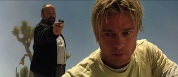 Movie still from “The Mexican” (2001), directed by Gore Verbinski – A man holding a gun in front of another man; Close Up shot, Low angle
