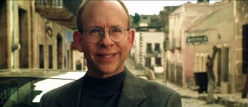 Movie still from “The Mexican” (2001), directed by Gore Verbinski – A person wearing a suit and glasses; Close Up shot, Low angle