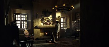 Movie still from “The Mexican” (2001), directed by Gore Verbinski – A man and a dog in front of a fire place; Wide shot, Low angle