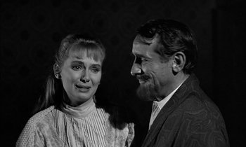 Movie still from “The Miracle Worker” (1962), directed by Arthur Penn – An older man standing next to an older woman in front of a black background; Close Up shot, Over the shoulder angle