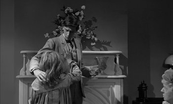 Movie still from “The Miracle Worker” (1962), directed by Arthur Penn – A man and a woman are dancing in front of a fireplace; Medium shot, Over the shoulder angle