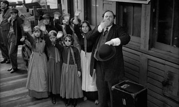 Movie still from “The Miracle Worker” (1962), directed by Arthur Penn – An old photo of a group of people standing in front of a train; Medium shot, Low angle