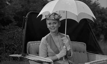 Movie still from “The Miracle Worker” (1962), directed by Arthur Penn – A woman sitting on a couch holding an umbrella; Medium shot, Low angle