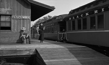 Movie still from “The Miracle Worker” (1962), directed by Arthur Penn – A black and white photo of a train station; Wide shot, Low angle