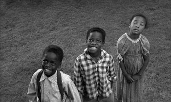 Movie still from “The Miracle Worker” (1962), directed by Arthur Penn – A group of children standing next to each other on a field; Medium shot, High angle