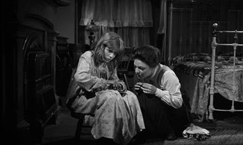 Movie still from “The Miracle Worker” (1962), directed by Arthur Penn – A woman and a girl sitting on the floor; Medium shot, High angle