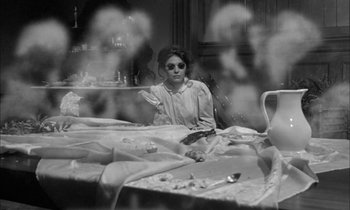 Movie still from “The Miracle Worker” (1962), directed by Arthur Penn – A woman sitting at a table with a knife in her hand; Medium shot, High angle