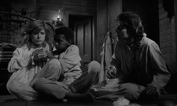 Movie still from “The Miracle Worker” (1962), directed by Arthur Penn – A group of people sitting on the floor; Medium shot, Over the shoulder angle