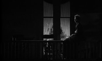 Movie still from “The Miracle Worker” (1962), directed by Arthur Penn – A man sitting on top of a wooden bench; Wide shot, Low angle