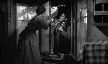 Movie still from “The Miracle Worker” (1962), directed by Arthur Penn – An old photo of a man and a woman looking at each other in a mirror; Medium shot, Over the shoulder angle