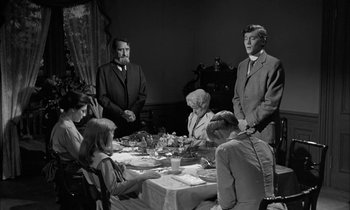 Movie still from “The Miracle Worker” (1962), directed by Arthur Penn – A group of people sitting at a table with plates of food on it; Medium shot, Over the shoulder angle