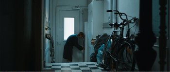 Movie still from “The Misfortunates” (2009), directed by Felix van Groeningen – A person in a room with a bunch of bikes; Wide shot, Low angle