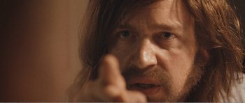 Movie still from “The Misfortunates” (2009), directed by Felix van Groeningen – A person with long hair and a beard; Extreme Close Up shot, Over the shoulder angle