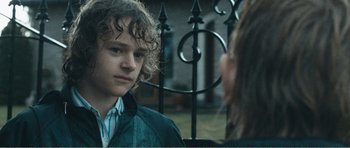Movie still from “The Misfortunates” (2009), directed by Felix van Groeningen – A man and a woman standing next to each other in front of an iron fence; Close Up shot, Over the shoulder angle