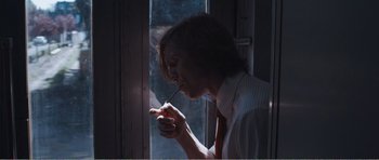 Movie still from “The Misfortunates” (2009), directed by Felix van Groeningen – A man smoking a cigarette in front of a window; Medium shot, Low angle