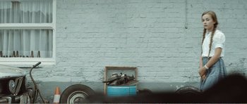 Movie still from “The Misfortunates” (2009), directed by Felix van Groeningen – An image of an old car that is parked on the side of the road; Wide shot, Low angle