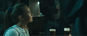 Movie still from “The Misfortunates” (2009), directed by Felix van Groeningen – A woman sitting at a table with a glass of beer; Close Up shot, Over the shoulder angle