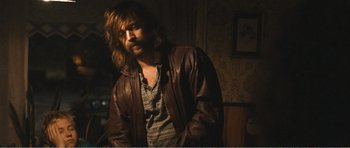 Movie still from “The Misfortunates” (2009), directed by Felix van Groeningen – A man with long hair wearing a brown leather jacket; Medium shot, Over the shoulder angle