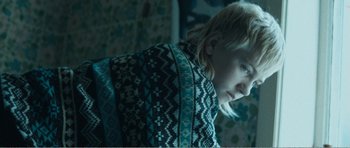 Movie still from “The Misfortunates” (2009), directed by Felix van Groeningen – A young person is wrapped up in a blanket; Close Up shot, High angle