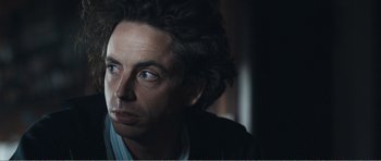 Movie still from “The Misfortunates” (2009), directed by Felix van Groeningen – A person wearing a suit and tie; Close Up shot, Over the shoulder angle