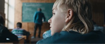 Movie still from “The Misfortunates” (2009), directed by Felix van Groeningen – A young boy sitting in front of a chalkboard; Close Up shot, Over the shoulder angle