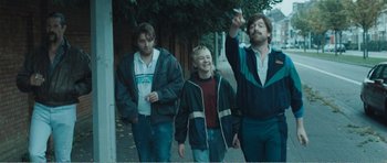 Movie still from “The Misfortunates” (2009), directed by Felix van Groeningen – A group of young men walking down a sidewalk; Medium shot, Low angle