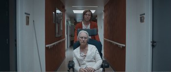 Movie still from “The Misfortunates” (2009), directed by Felix van Groeningen – A woman sitting in a chair next to an older woman; Medium shot, Low angle