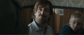 Movie still from “The Misfortunates” (2009), directed by Felix van Groeningen – A person with a beard and mustache; Close Up shot, Over the shoulder angle