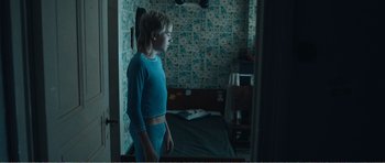 Movie still from “The Misfortunates” (2009), directed by Felix van Groeningen – A woman standing in front of a mirror in a room; Medium shot, Over the shoulder angle