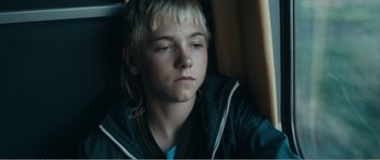 Movie still from “The Misfortunates” (2009), directed by Felix van Groeningen – A young boy sitting in a car looking sad; Close Up shot, High angle