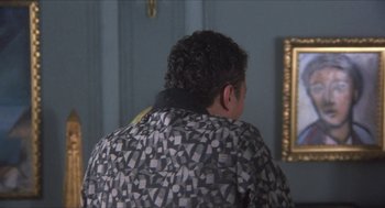 Movie still from “The Moderns” (1988), directed by Alan Rudolph – A man in a black and white jacket looking at a mirror; Medium shot, Over the shoulder angle