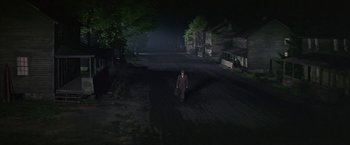 Movie still from “The Molly Maguires” (1970), directed by Martin Ritt – A man is standing in the middle of the street at night; Extreme Wide shot, High angle