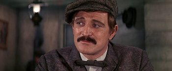 Movie still from “The Molly Maguires” (1970), directed by Martin Ritt – A person wearing a suit and a hat; Close Up shot, Over the shoulder angle